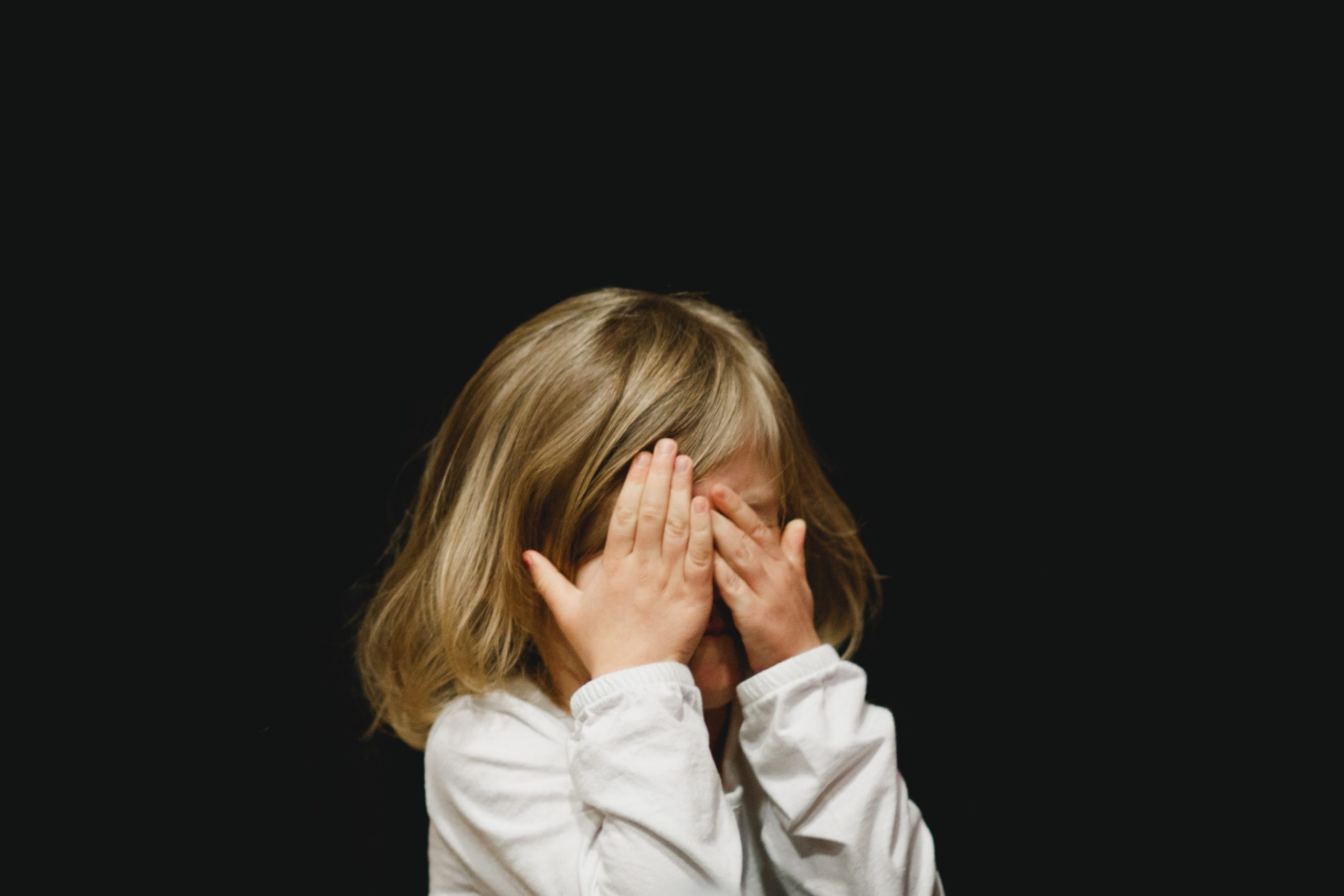 Child covering their face with hands
