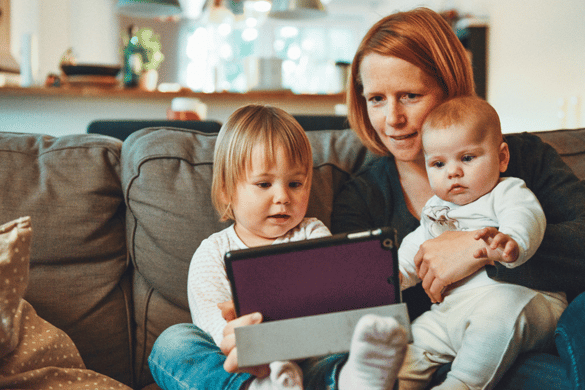Parent with two young children holding tablet